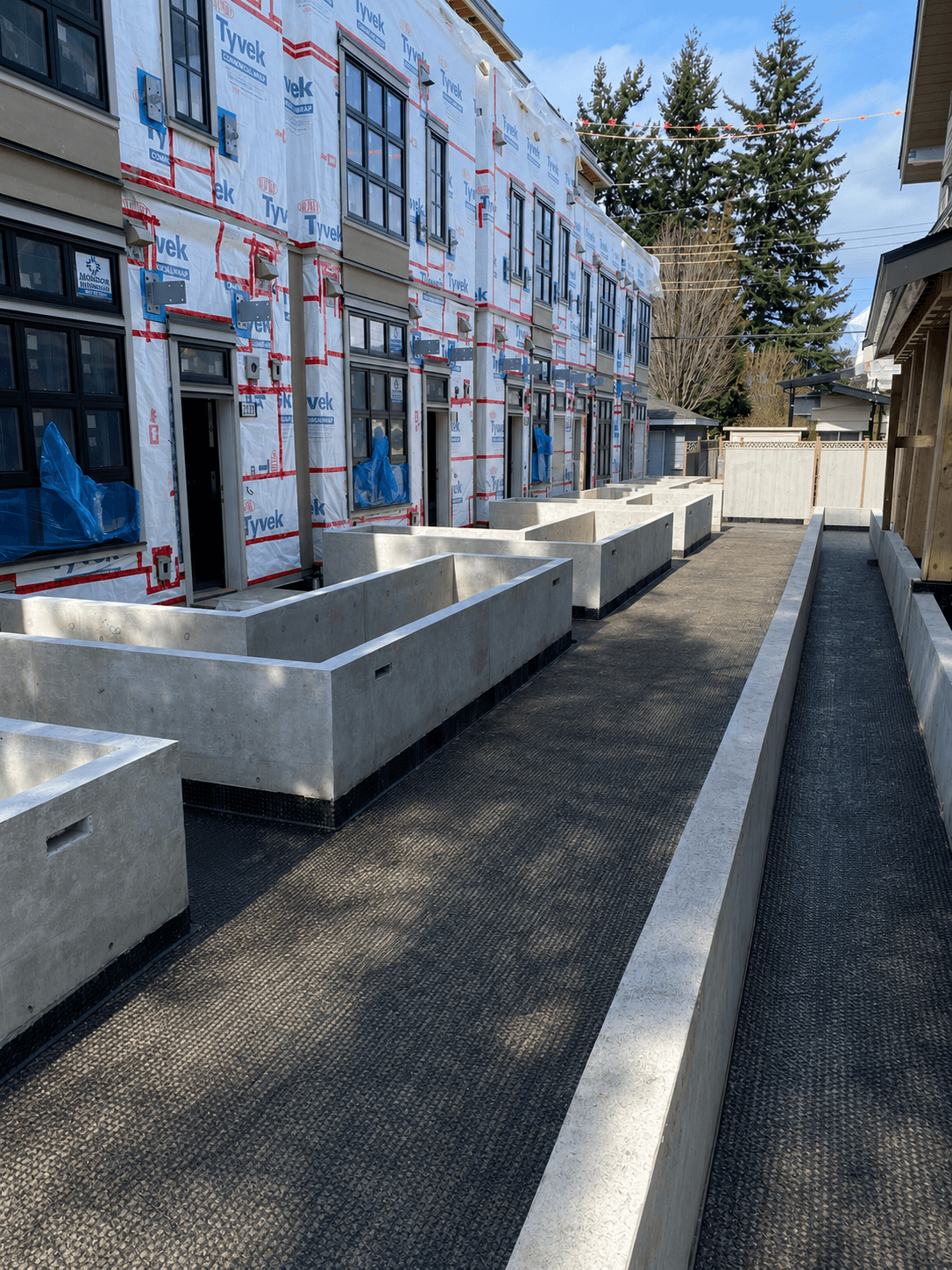 Concrete planter walls along the courtyard walkway, opposite angle