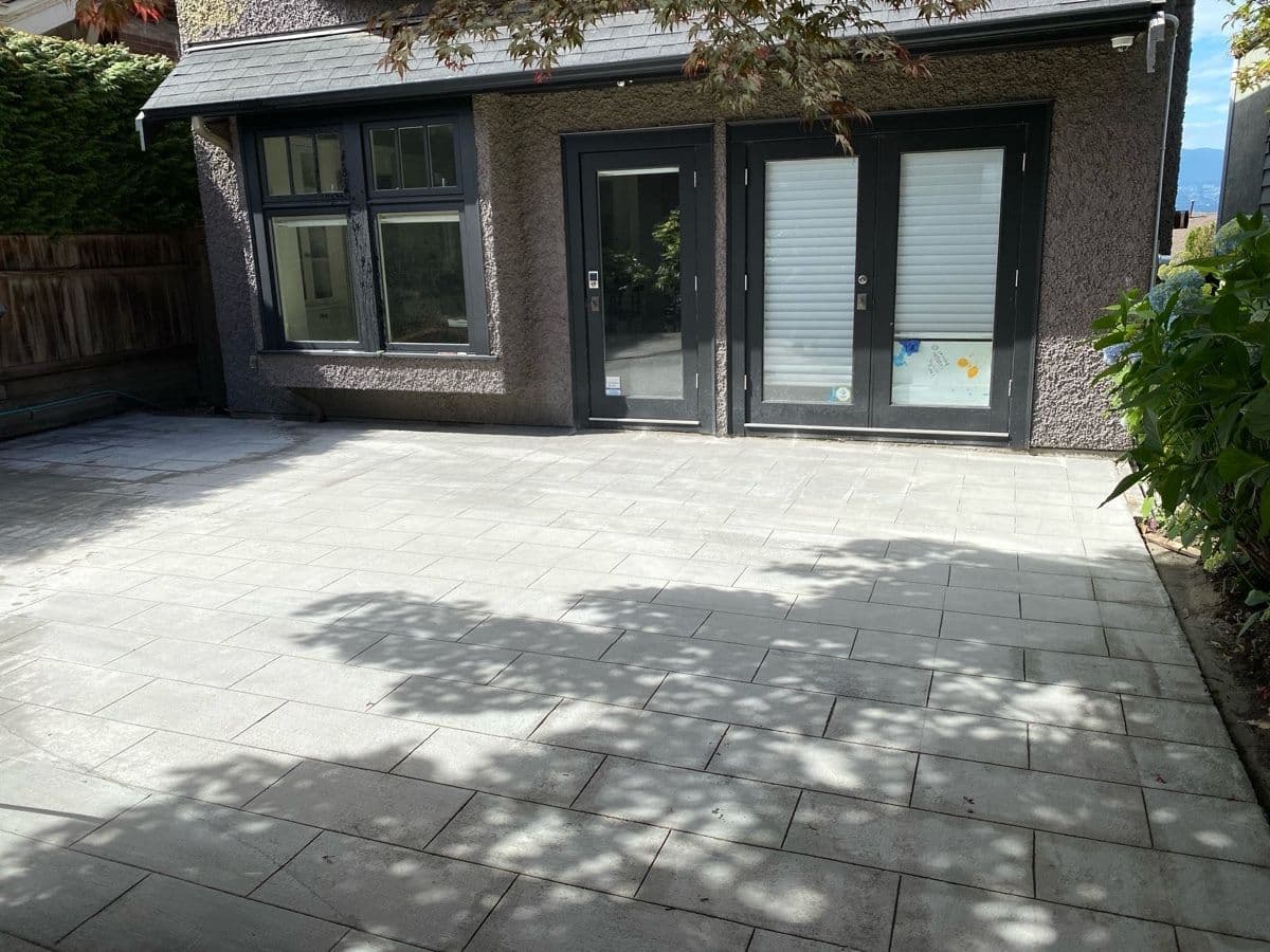 Finished interlocking paver patio outside the home's back entrance