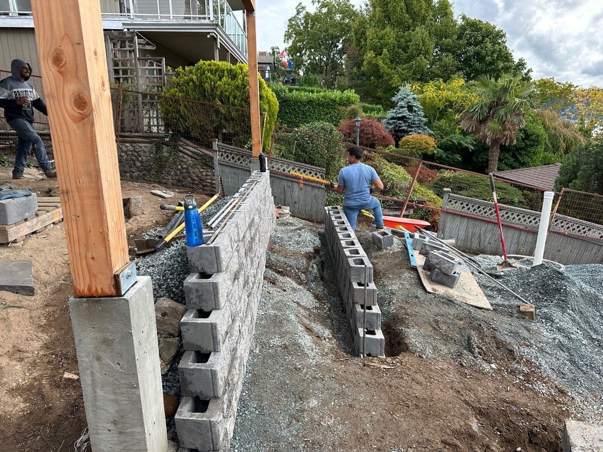 Concrete block retaining wall under construction with rebar and forms