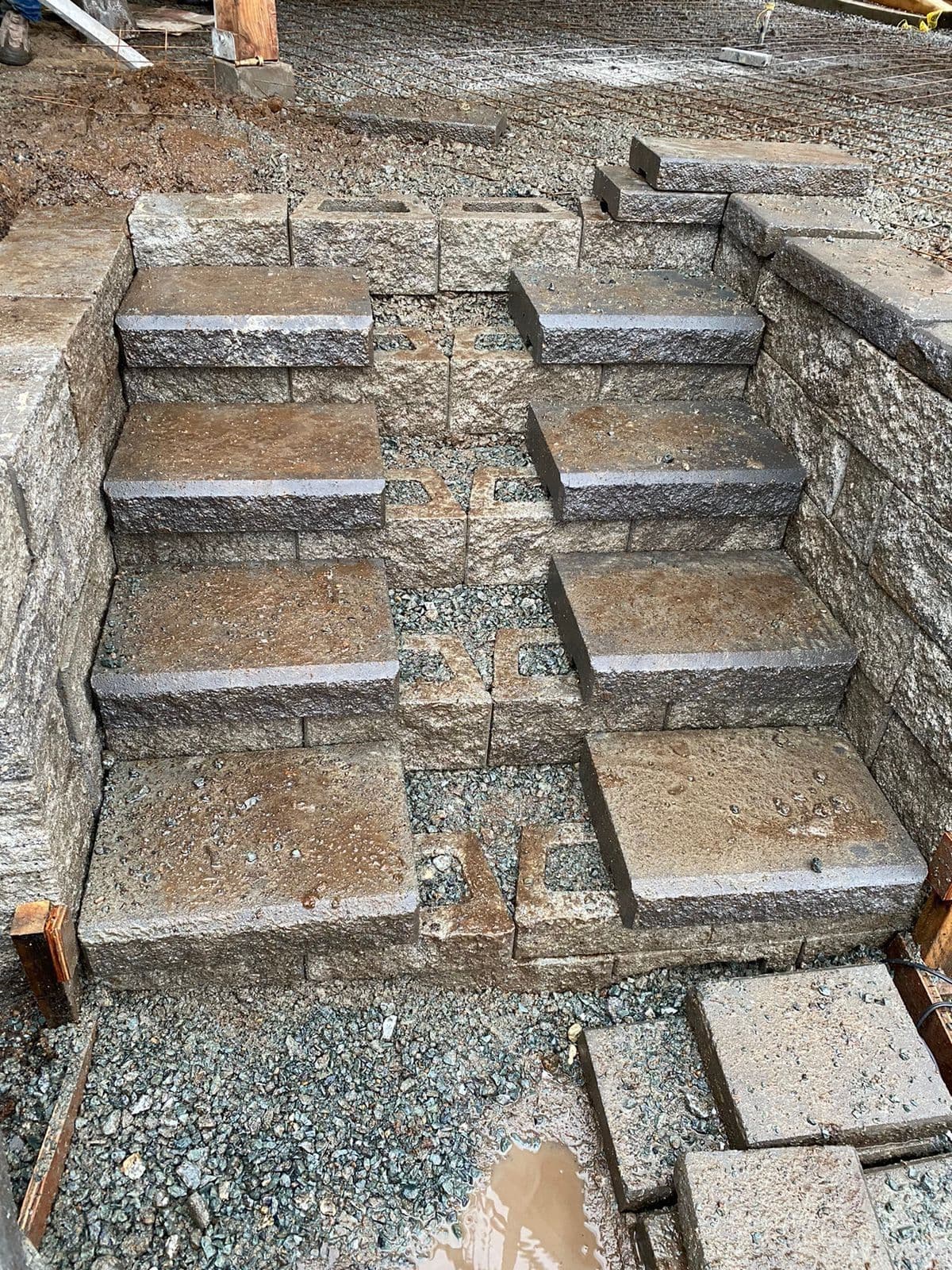 Stone-block retaining wall steps under construction