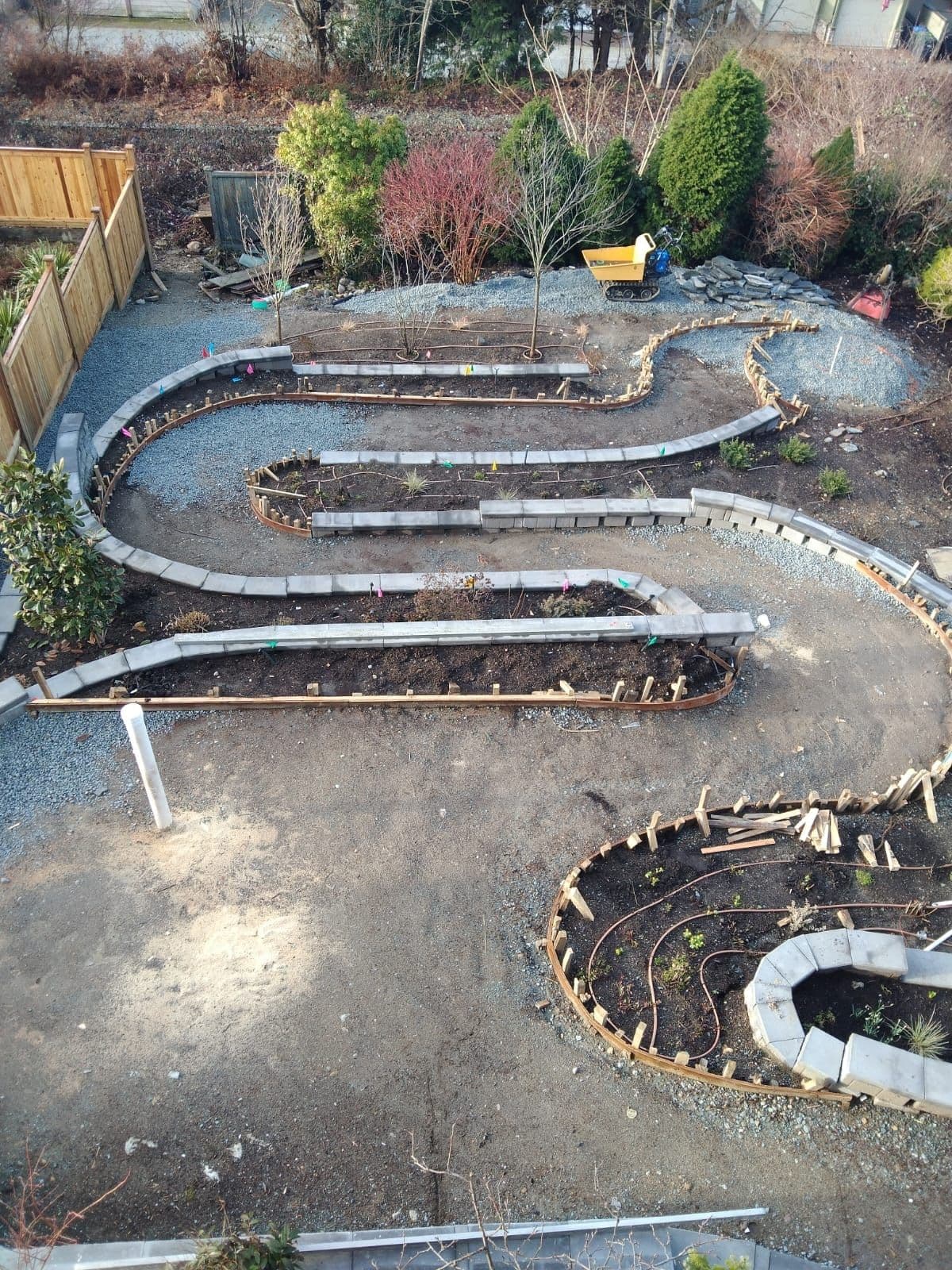 Curved planter retaining walls being built with wood stakes and forms