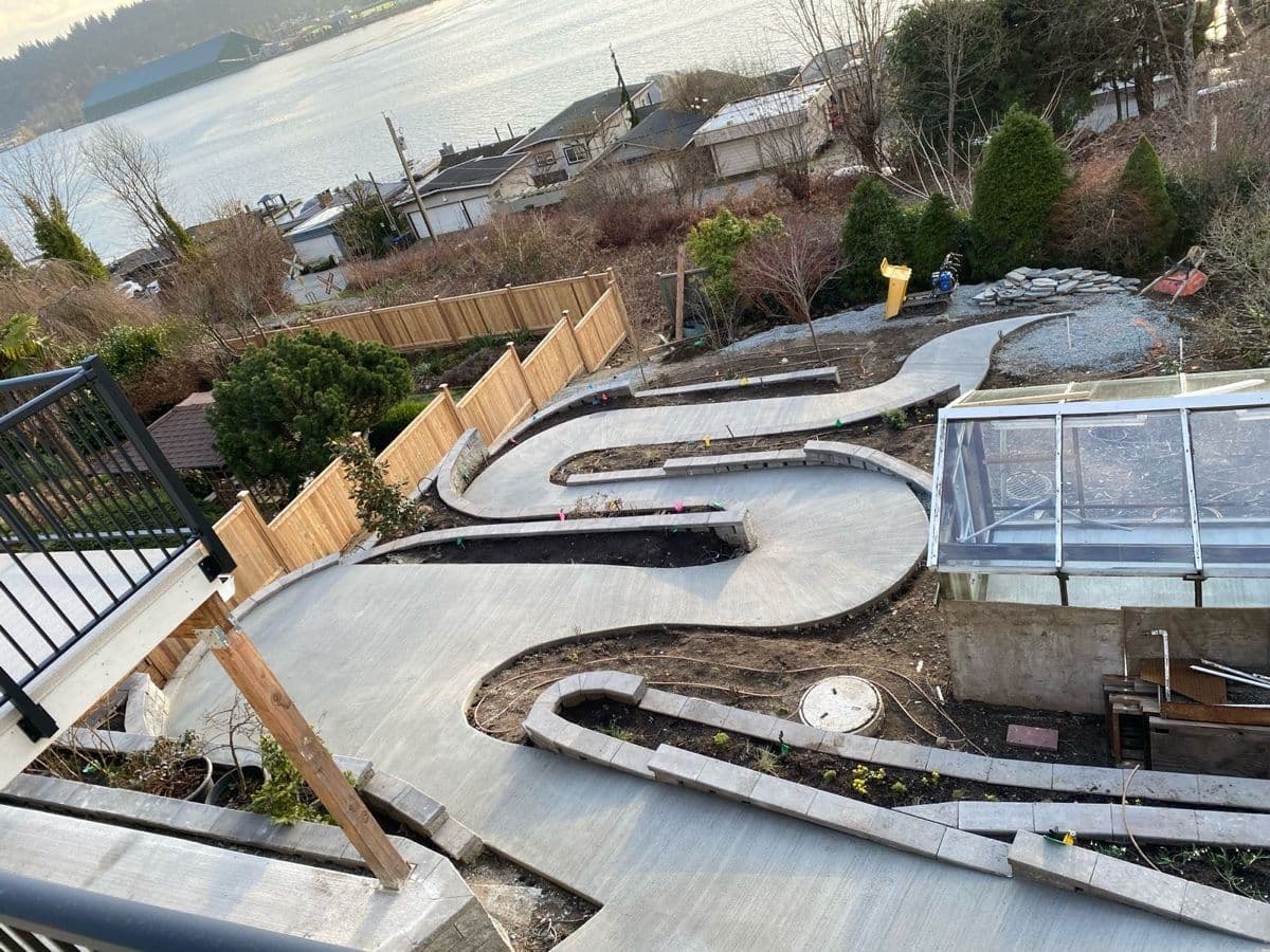 Finished curved concrete walkway poured between the new retaining walls