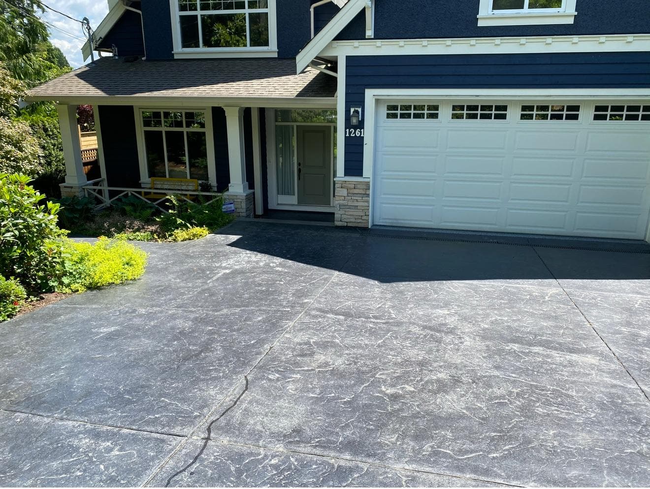 Faded, worn stamped driveway — before