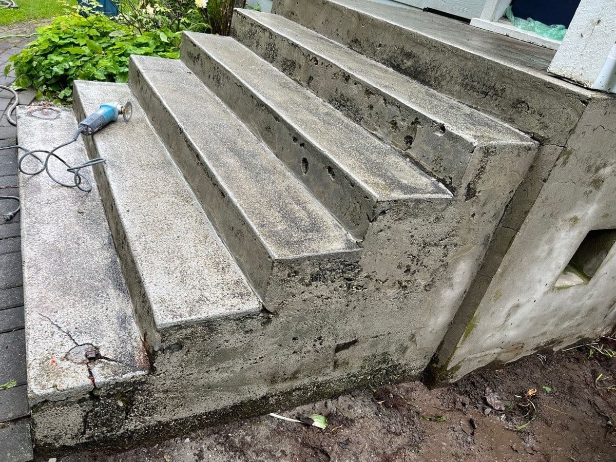 Close-up of spalled concrete steps mid-repair